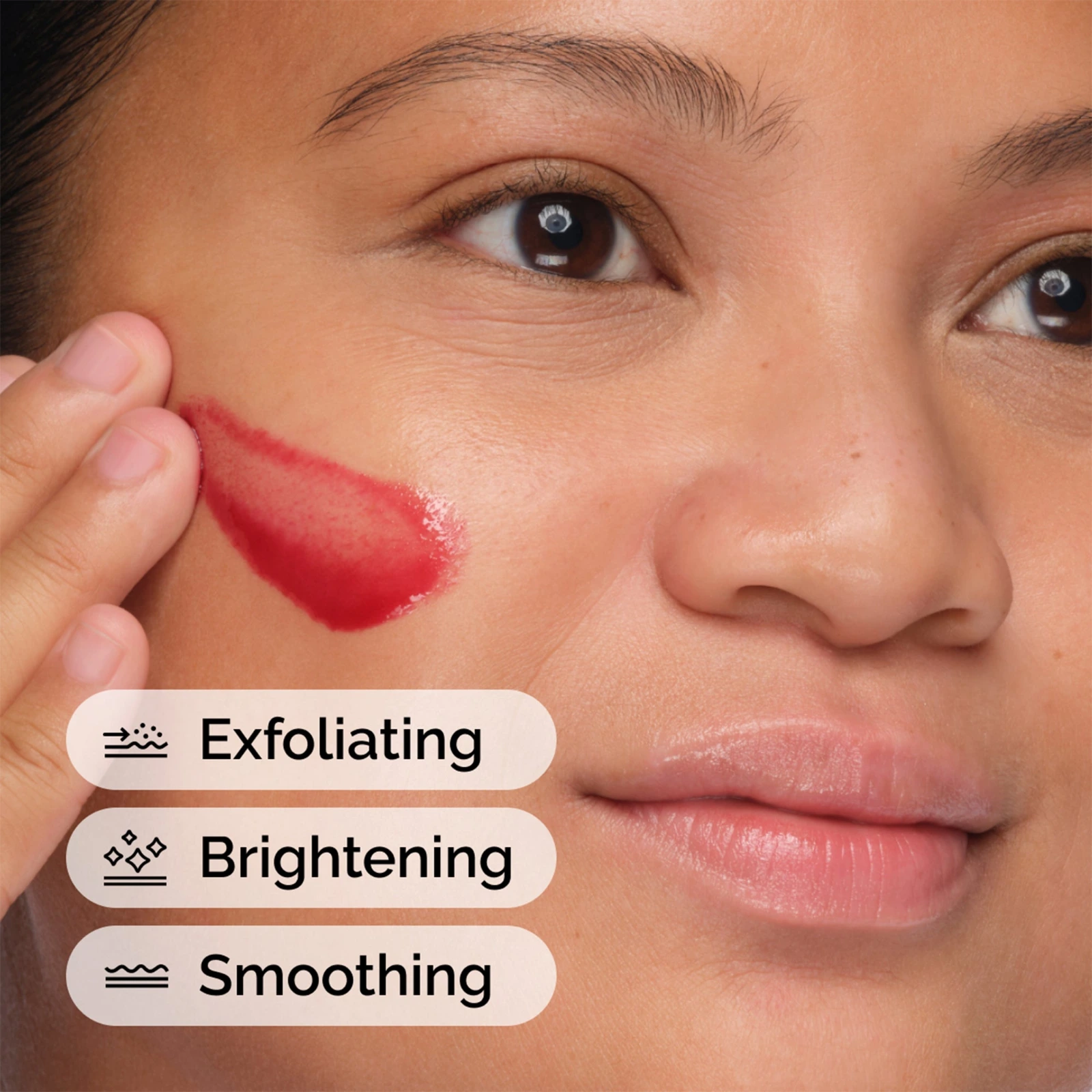 The Ordinary Peeling Solution being applied to the cheek, showing the red colour that comes from black carrot extract