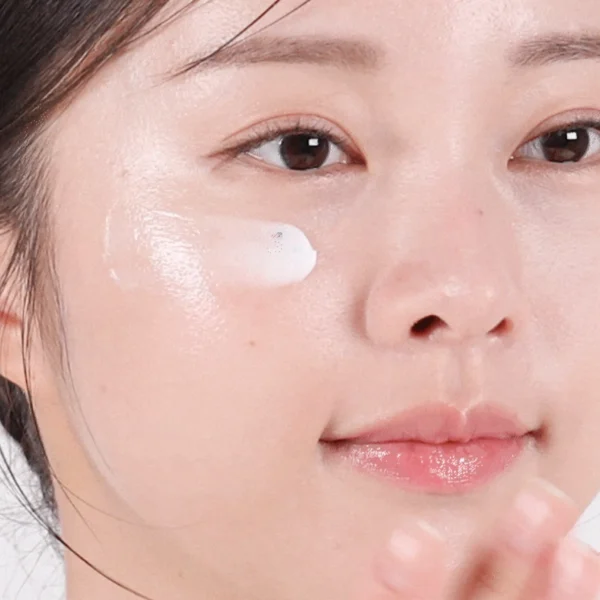 Model applying VT PDRN Cream 100 to her cheek