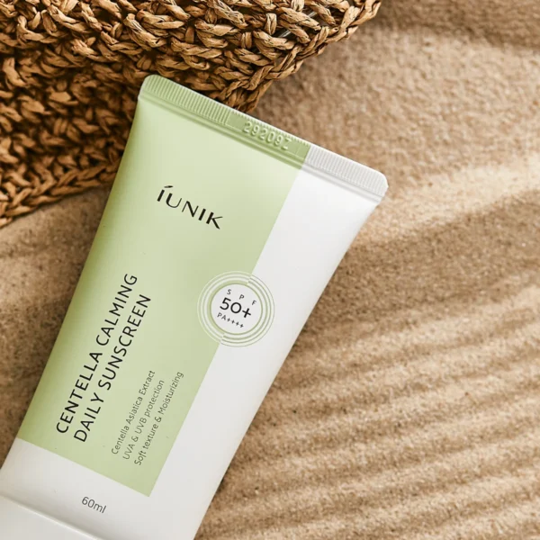 iUNIK Centella Calming Daily Sunscreen tube on sand