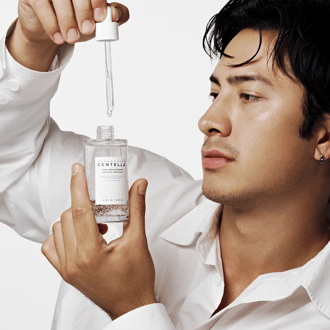 Holding SKIN1004 Centella Tone Brightening Ampoule dropper with Madewhite capsules visible