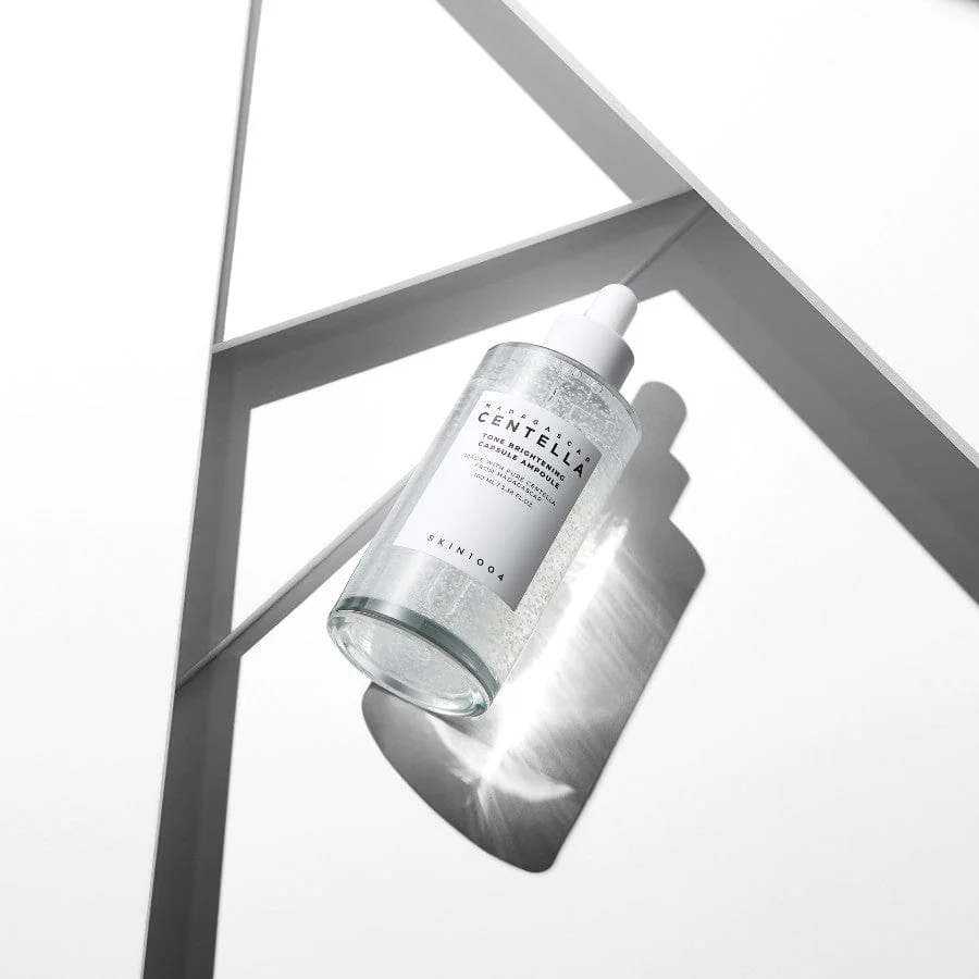 SKIN1004 Centella Tone Brightening Ampoule bottle on white surface with geometric light